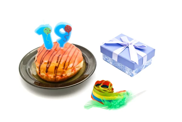 Donut com dezenove anos vela de aniversário, apito e presente — Fotografia de Stock