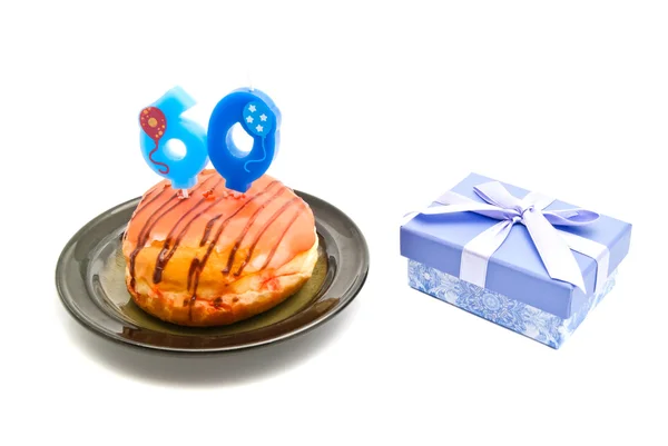 Donut with sixty years birthday candle and gift on white — Stock Photo, Image