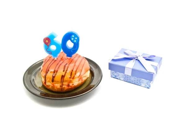 Donut mit sechzig Jahre Geburtstagskerze und Geschenk — Stockfoto