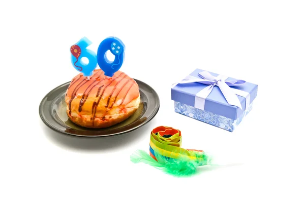 Donut avec soixante ans bougie d'anniversaire, sifflet et cadeau sur whit — Photo
