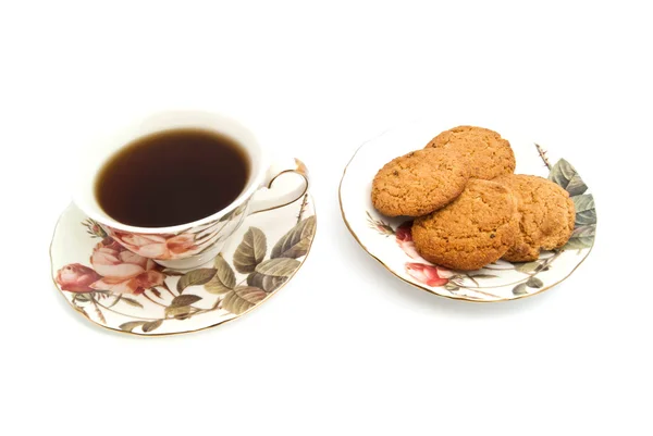 Mug of tea and oatmeal cookies on white — Stock Photo, Image