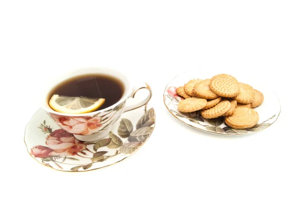 Xícara de chá com limão e alguns biscoitos — Fotografia de Stock