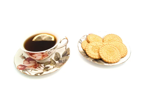 Xícara de chá com limão e biscoitos saborosos — Fotografia de Stock