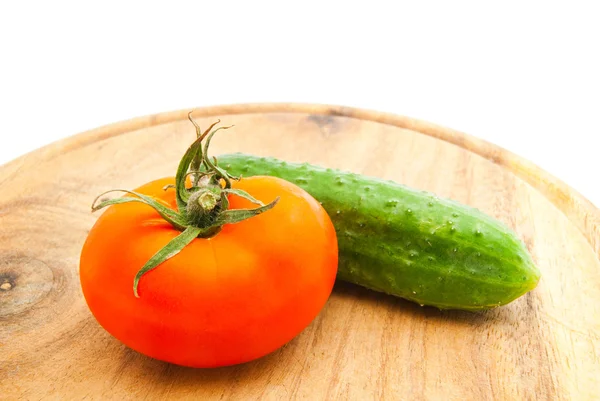 Tomate fresco e pepino na tábua de corte — Fotografia de Stock