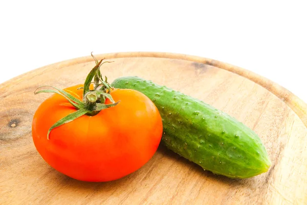 Red tomato and cucumber on cutting board — Stock Photo, Image