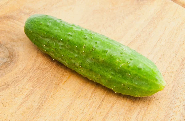 Single cucumber on cutting board — Stock Photo, Image