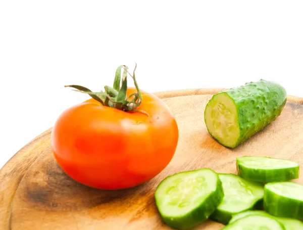 Pepino e tomate vermelho na placa de corte — Fotografia de Stock