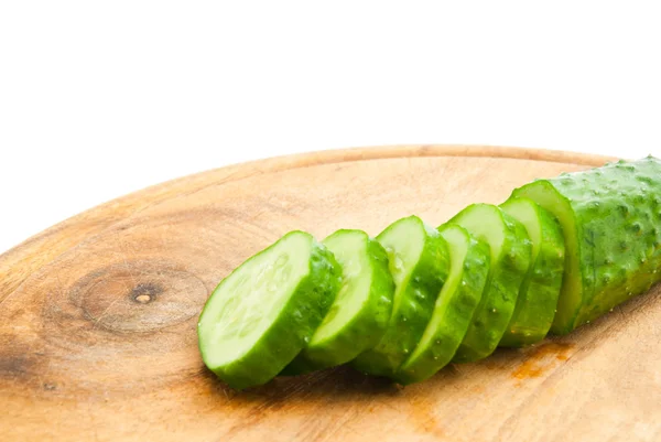 Cucumber with slices on wooden cutting board — Stock Photo, Image