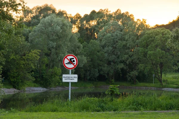 Warning sign next to the pond in the park Stock Image