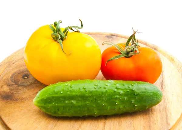 Twee tomaten en komkommer op houten snijplank — Stockfoto