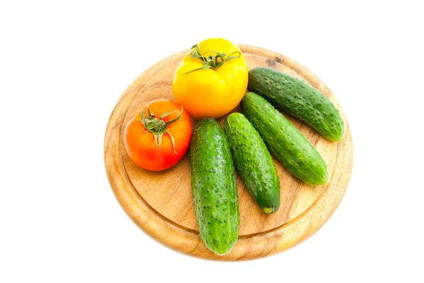 Cucumbers and tomatoes on cutting board — Stock Photo, Image