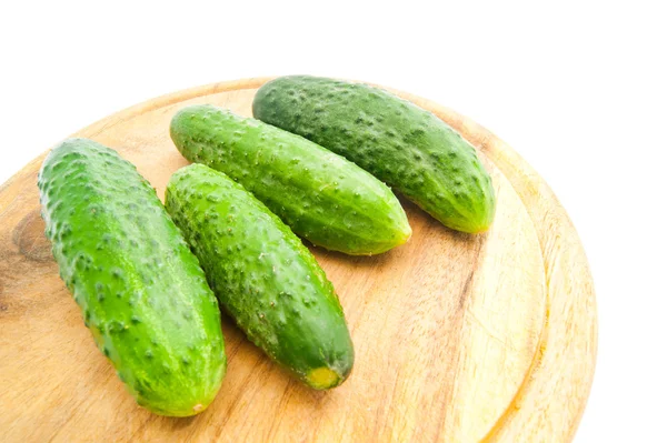 Vier komkommers op snijplank — Stockfoto