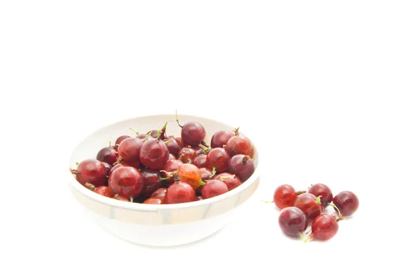 Rote Stachelbeeren auf einem Teller auf weißem — Stockfoto