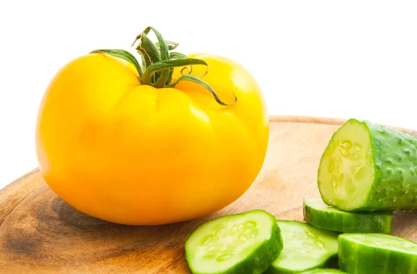 Komkommer met segmenten en tomaat op snijplank — Stockfoto