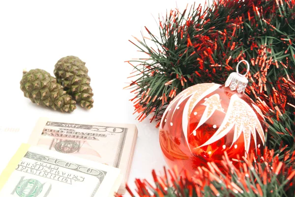 Christmas tree toy, cones, tinsel and banknotes — Stock Photo, Image