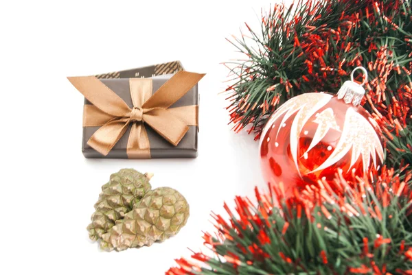 Weihnachtsbaumspielzeug, Zapfen, Lametta und braune Geschenkschachtel — Stockfoto