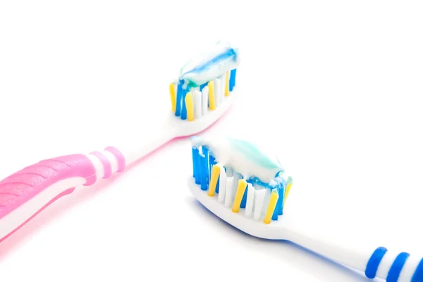 Toothbrushes with paste on white — Stock Photo, Image