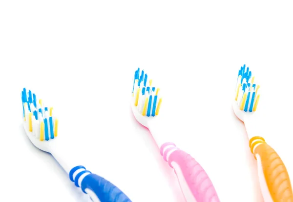 Tres cepillos de dientes de color en blanco — Foto de Stock