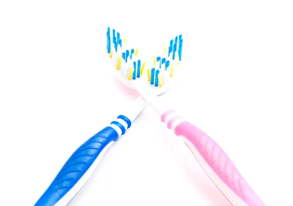 Cepillos de dientes de color rosa y azul sobre blanco — Foto de Stock