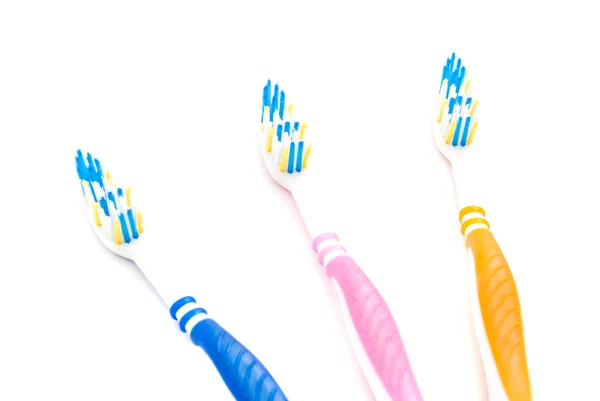 Tres cepillos de dientes de colores en blanco — Foto de Stock