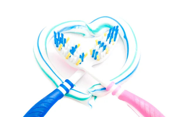 Toothbrushes in heart on white — Stock Photo, Image