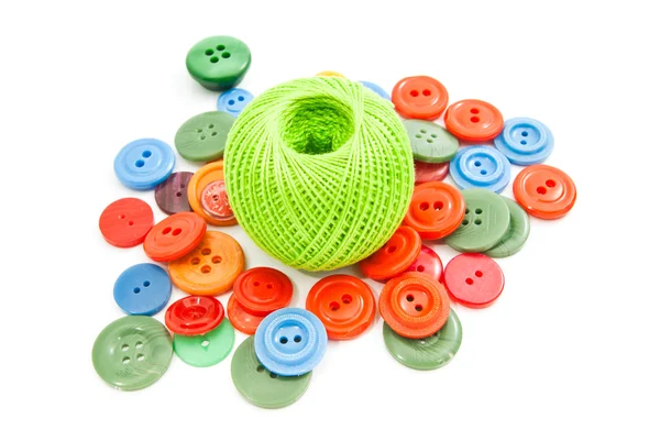 Green ball of thread and colorful buttons — Stock Photo, Image