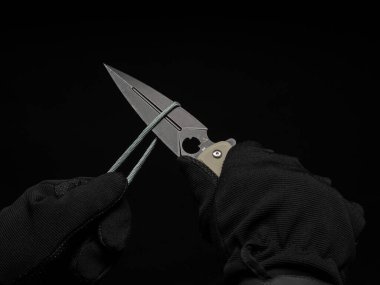 Siyah eldivenli eller kordonu çakıyla kesmiş.