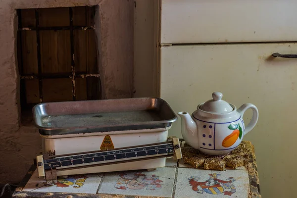 旧秤和一个茶壶放在废弃房子的桌子上 — 图库照片