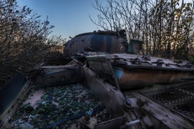 Yeşil yosunlu paslı eski bir tank.