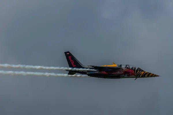 雨が降る航空ショーで赤い牛からカラフルなジェット飛行機 — ストック写真
