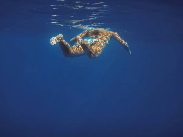 ビキニ姿の女性が休暇で青い海に浮かぶ — ストック写真