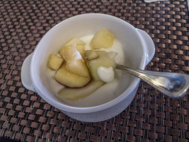 Yoğurt ve meyve kasede, kahvaltıda kaşıkla tatilde.