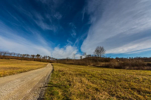 Estrada Terra Uma Colina Com Floresta Nuvens Finas Céu Primavera — Fotografia de Stock