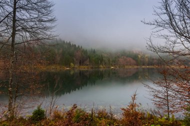 Güzel dağ gölü. Sonbahar ormanından yansıması var. Tatilde yürüyüş yaparken.