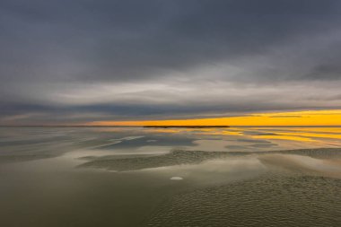 Donmuş bir gölde, yağmurlu bulutlu ve kışın güneşli lekeler.