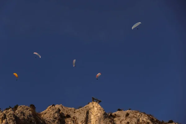 Pět Paraglidistů Tmavě Modré Obloze Skalnaté Stěně Vzletem — Stock fotografie