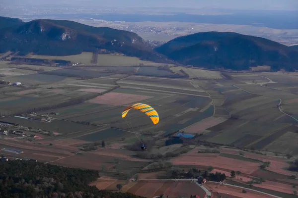 一个黄色的滑翔伞飘浮在从上方眺望的风景中 — 图库照片