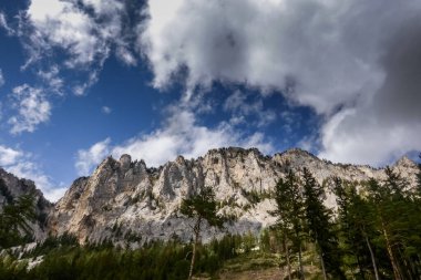 Yürüyüş yaparken mavi gökyüzünde beyaz bulutları olan güzel dağlar