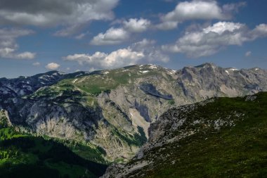 Yazın gökyüzünde yeşil ve bulutlu harika dağlar.