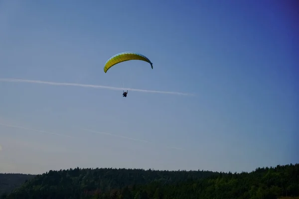 山の青い空に一本の青い黄色のパラグライダー — ストック写真
