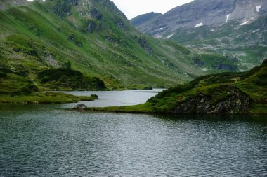 Tatilde yürüyüş yaparken gölü olan dağ manzarası