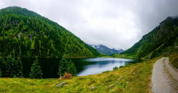 Górskie Jezioro Zielonymi Górami Drzewami Pobliżu Polnej Drogi Widok Panoramy — Zdjęcie stockowe