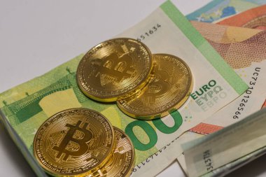 Farklı avro banknotları üzerinde uzanan altın değerli bitcoin 'ler ayrıntılı görünüm