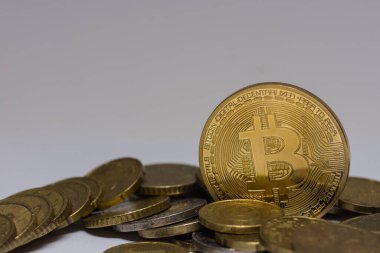 Altın değerli bitcoin gri arka planlı diğer madeni paraların arasında duruyor