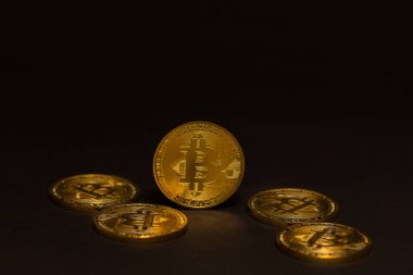 Siyah arka planda altın parlayan pahalı bitcoin 'ler
