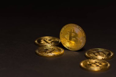 Siyah arka planda duran altın renkli, pahalı bitcoinler.