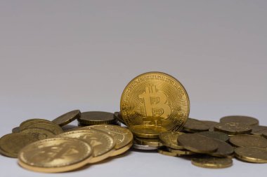 Gri arkaplanı olan diğer paraların arasında duran altın değerli bitcoin