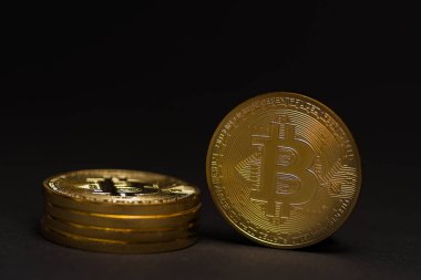 Siyah arkaplan detay görünümünde duran bir yığın altın parlayan değerli bitcoin