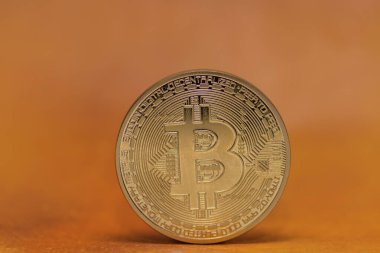Turuncu arkaplan detay görünümlü tek bitcoin para