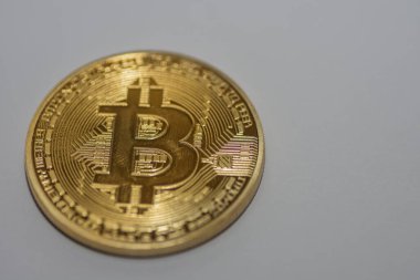 Tek bitcoin sol tarafta gri arkaplan detay görünümünde yatar